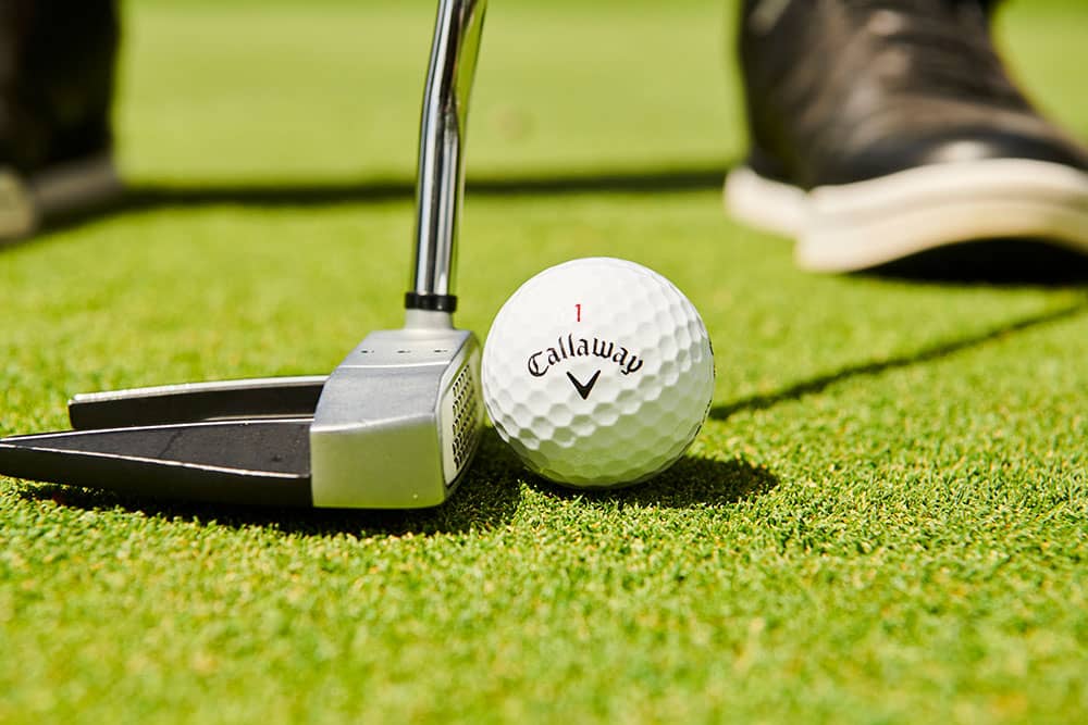 player with putter on green